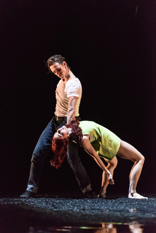 Polunin in a white t shirt holds Polunin by her neck as she does a back bend